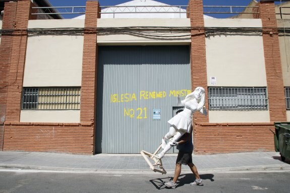 Un artista con un ninot en el polígono de la Ciudad Fallera. :: irene marsilla