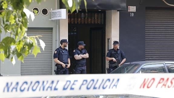 Agentes de la Policía Nacional, en la puerta del patio donde vivía el detenido. 
