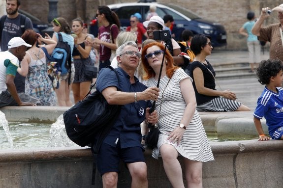 Dos turistas se fotografían en el centro de la ciudad.