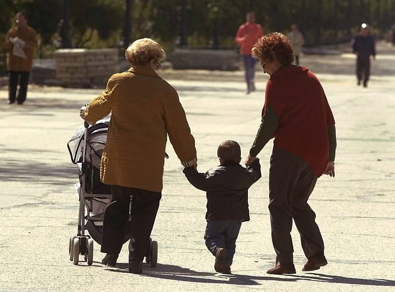 Dos ancianas paseando con su nieto. 