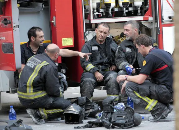 Un grupo de bomberos descansa tras la intervención en un incendio. :: txema rodríguez
