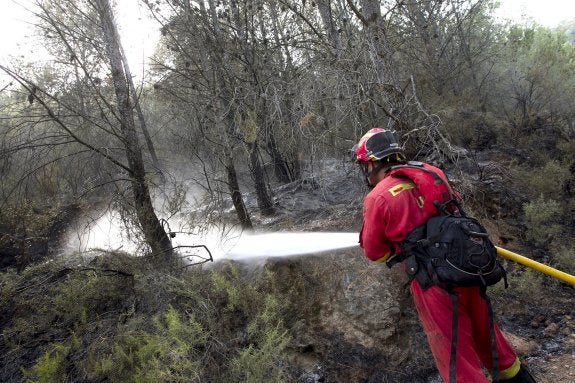 Un bombero sofoca un rebrote del fuego. :: EFE/Domenech Castelló