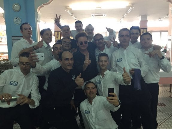 El cantante Bono, en el centro de la imagen, rodeado por los trabajadores de La Pepica. :: lp