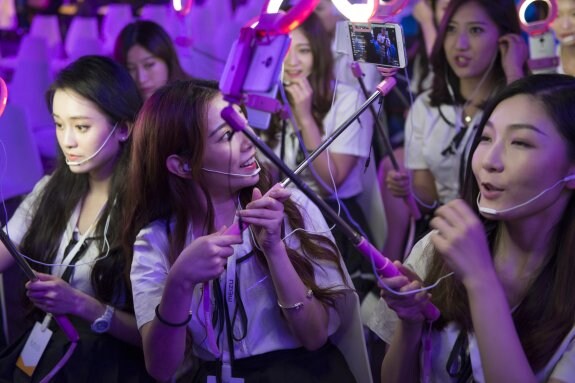 Un grupo de chinas en una sesión de selfis de estas nuevas aplicaciones que se han puesto de moda en el gigante asiático. Arriba a la derecha, algunos ejemplos. :: Z. Aldama