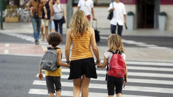 Dos niños acuden al colegio el primer día del curso.