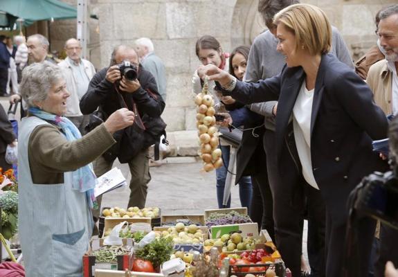 La secretaria general del PP, María Dolores de Cospedal (d), durante la visita que ha realizado al mercado de abastos, dentro de la campaña electoral para las elecciones gallegas, esta mañana en Santiago de Compostela.