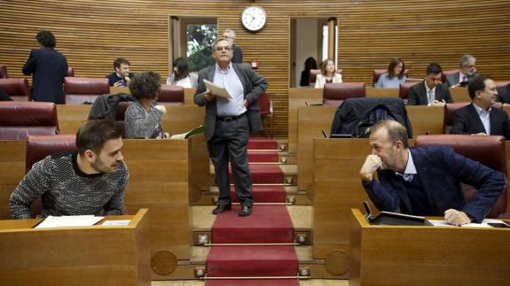 El portavoz de Ciudadanos, Alexis Marí (d), conversa con el de Compromís, Fran Ferri, durante el pleno de Les Corts Valencianes que debate y vota hoy propuestas sobre el sector citrícola, la violencia machista o el empleo estable.