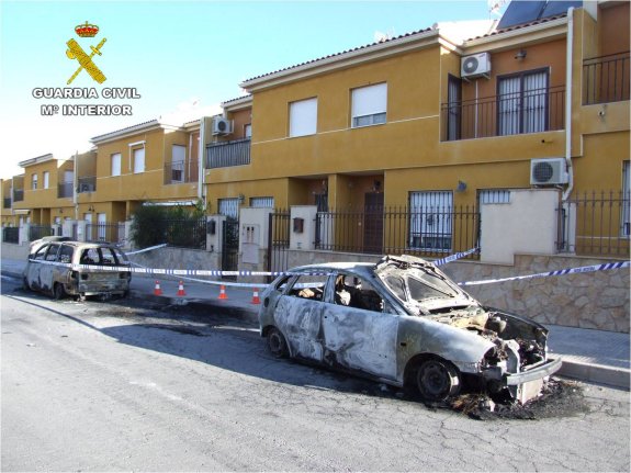 El coche quemado del agente junto a la puerta de su domicilio. :: guardia civil
