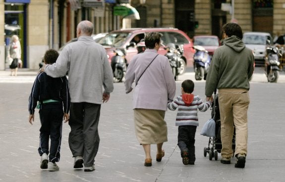 Tres generaciones de una familia pasean por la calle. :: LOBO ALTUNA