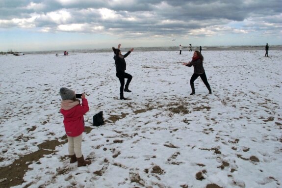 Niños y mayores disfrutaron de la nieve ayer por la mañana en las playas de Dénia. :: Tino Calvo