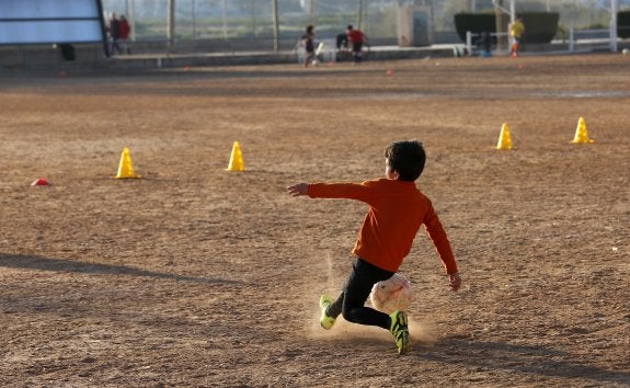 Un niño juega en el actual terreno de juego de la Escuela de Fútbol de Vinalesa.
