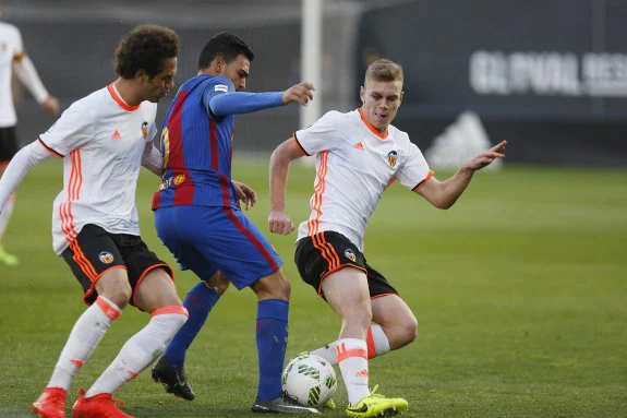 Quim y Lato intentan arrebatar el balón a Dani Romera durante el Mestalla-Barça. :: jesús signes
