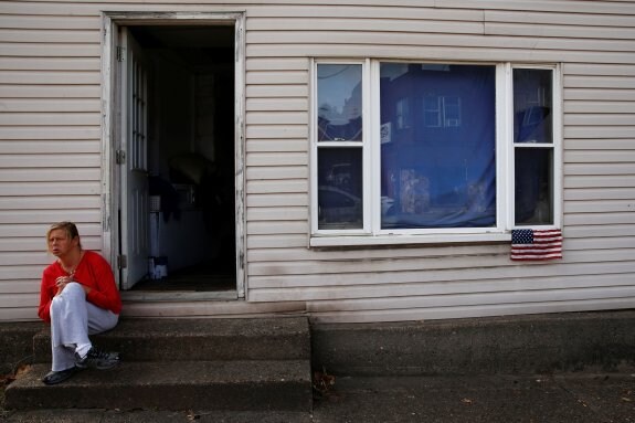 Una mujer, sentada a la puerta de su casa en la localidad de East Liverpool, Ohio. :: reuters