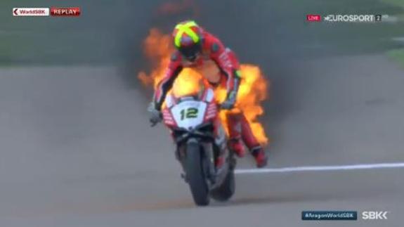 El piloto Xavi Forés, en el momento en que intenta bajarse de la moto envuelta en fuego.