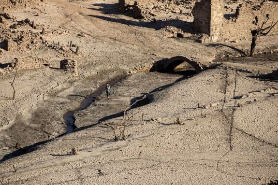 Un hombre camina por el embalse vacío de Mansilla, en La Rioja. La ausencia de precipitaciones ha hecho emerger el antiguo pueblo que había quedado sumergido bajo el agua. :: césar manso/afp