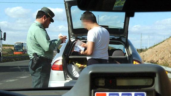 Un miembro de la Guardia Civil de Tráfico, poniendo una multa a un conductor por exceso de velocidad.