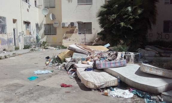 Colchones y basura acumulada en el patio interior del bloque de viviendas de las Casitas Rosa recayente a Padre Antón Martín. :: Lp