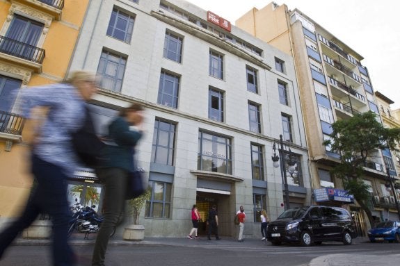 Varias personas pasan ante la sede del PSPV en la calle Blanquerías de Valencia. :: damián torres