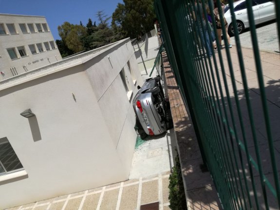 El coche volcó dentro del recinto escolar. :: LP