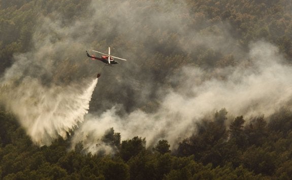 Un helicóptero suelta el agua sobre el incendio de Artana el pasado verano. :: damián torres