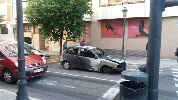 El coche calcinado en medio de la calzada.