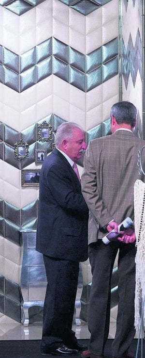Unos visitantes observan uno de los expositores de Cevisama. :: Damián Torres