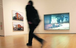 Un visitante de la exposición del IVAM pasa frente a algunas de las fotografías de la muestra. ::                             JUANJO MONZÓ