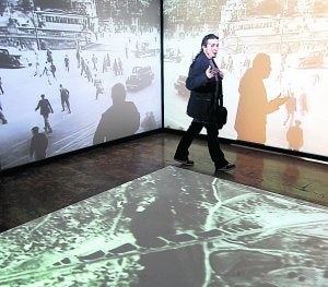 Un hombre recorre una videoinstalación de 'Después de la alambrada', ayer, en La Nau. ::
EFE/FÖRSTERLING