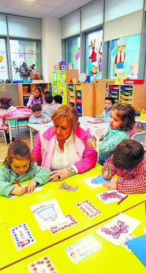 Una maestra atiende a sus                        alumnos en clase. ::                             ÁLEX PIÑA