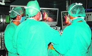 Tres médicos observan una pantalla durante una intervención en un quirófano. ::
LP