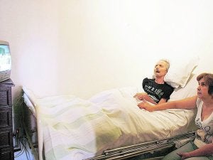 Una mujer, junto a su esposo enfermo. / Reuters / Nacho Doce