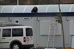 Un operario trabaja en la instalación de un barracón en Puerto de Sagunto.