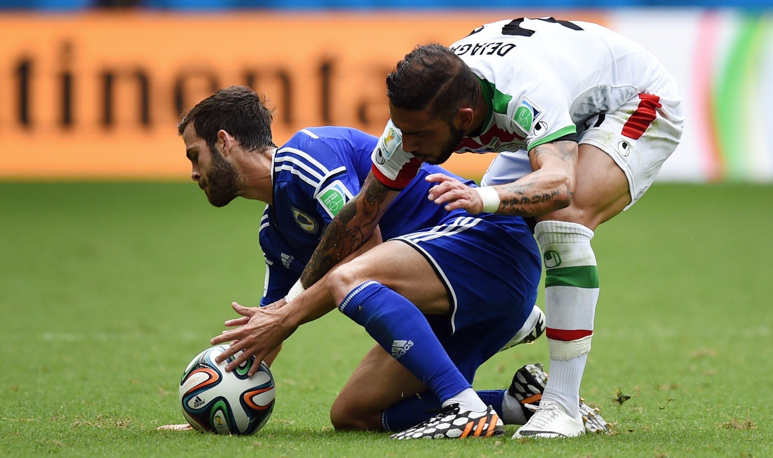 Pjianic (i) y Dejagah pelean por una pelota.