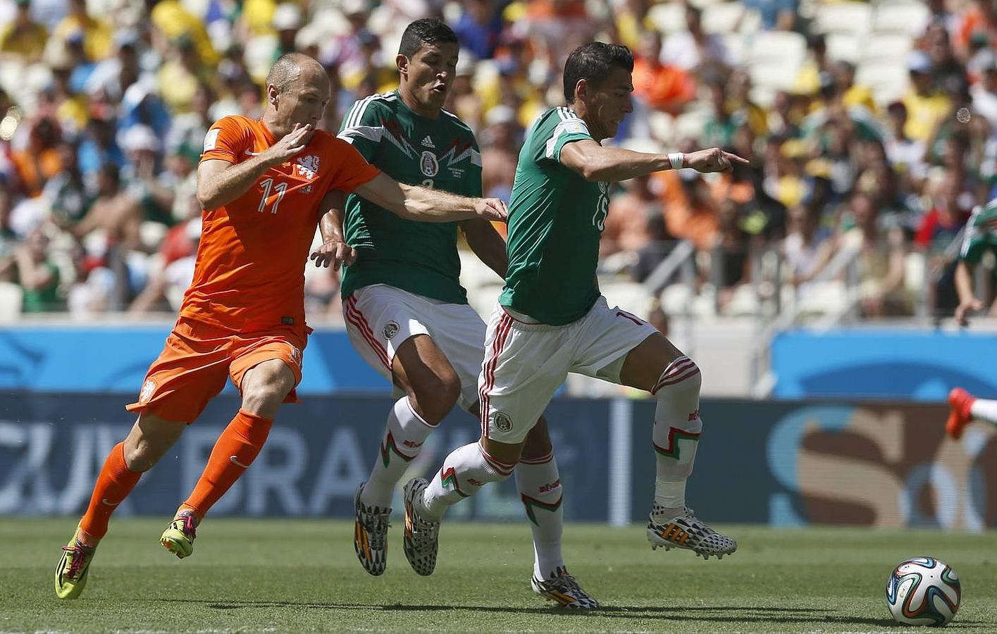 Robben intenta hacerse con el balón entre dos defensores mexicanos.