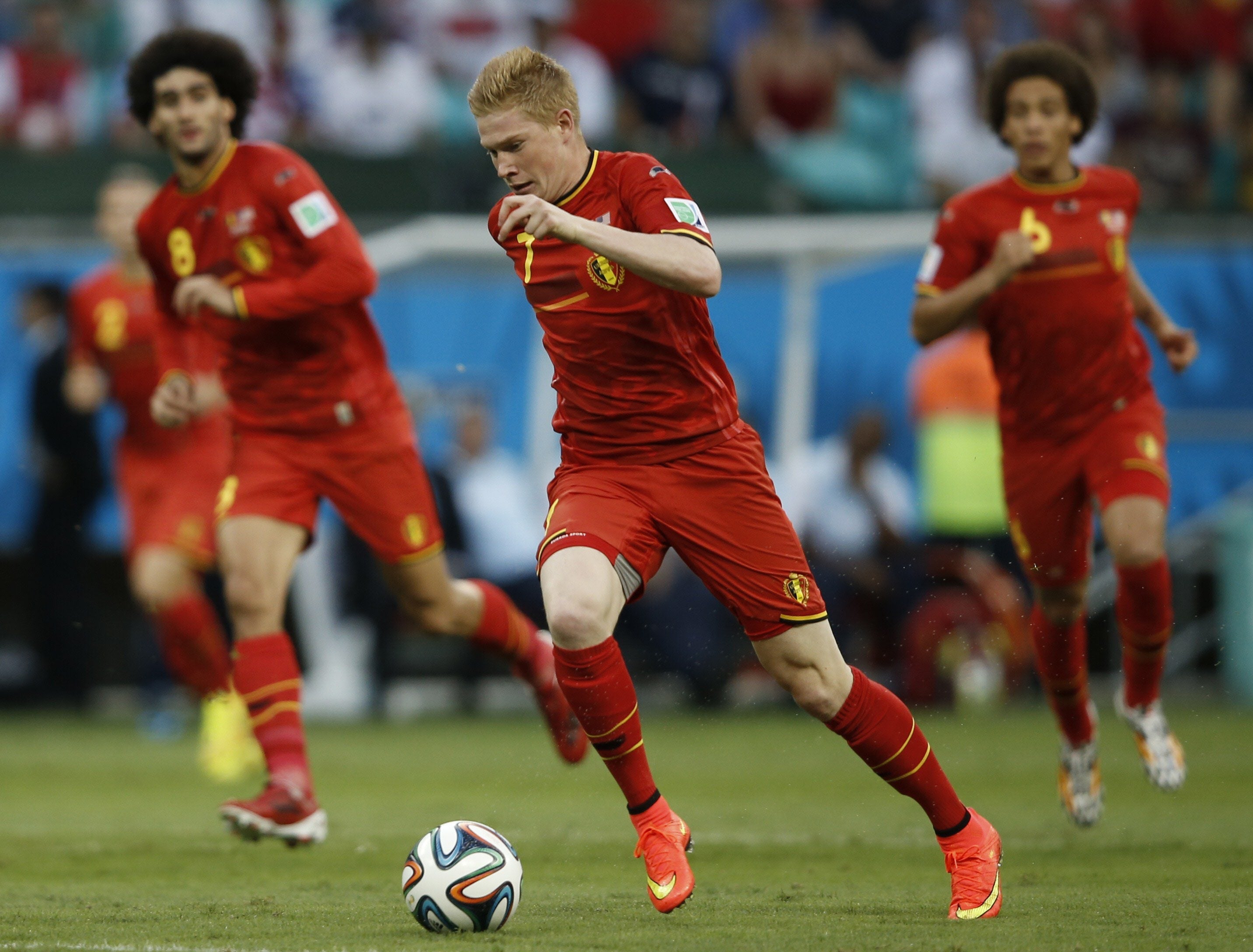 Kevin De Bruyne (C) conduce el balón junto a sus compañeros.