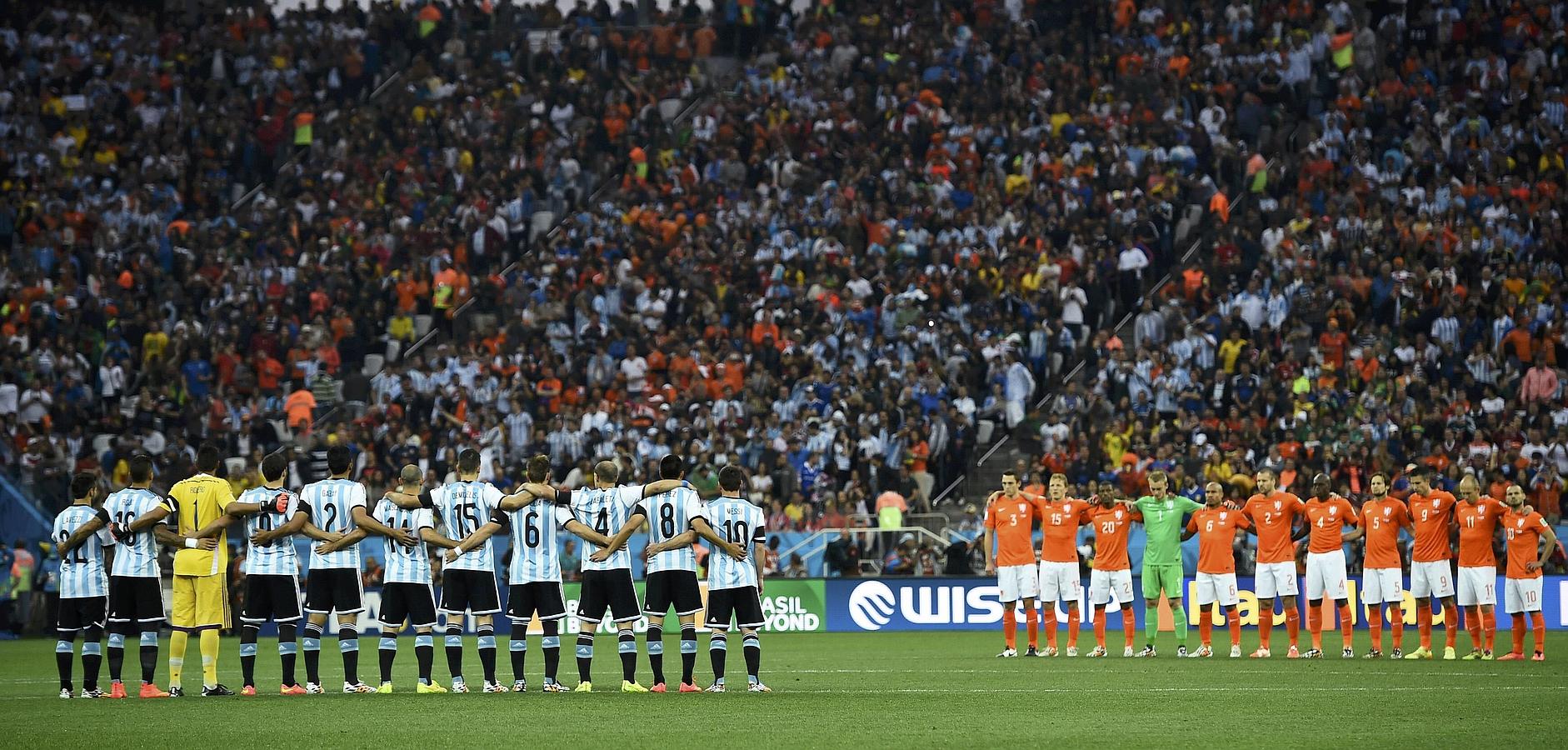 Jugadores argentinos (i) y holandeses, durante el minuto de silencia en memoria de Alfredo di Stéfano.