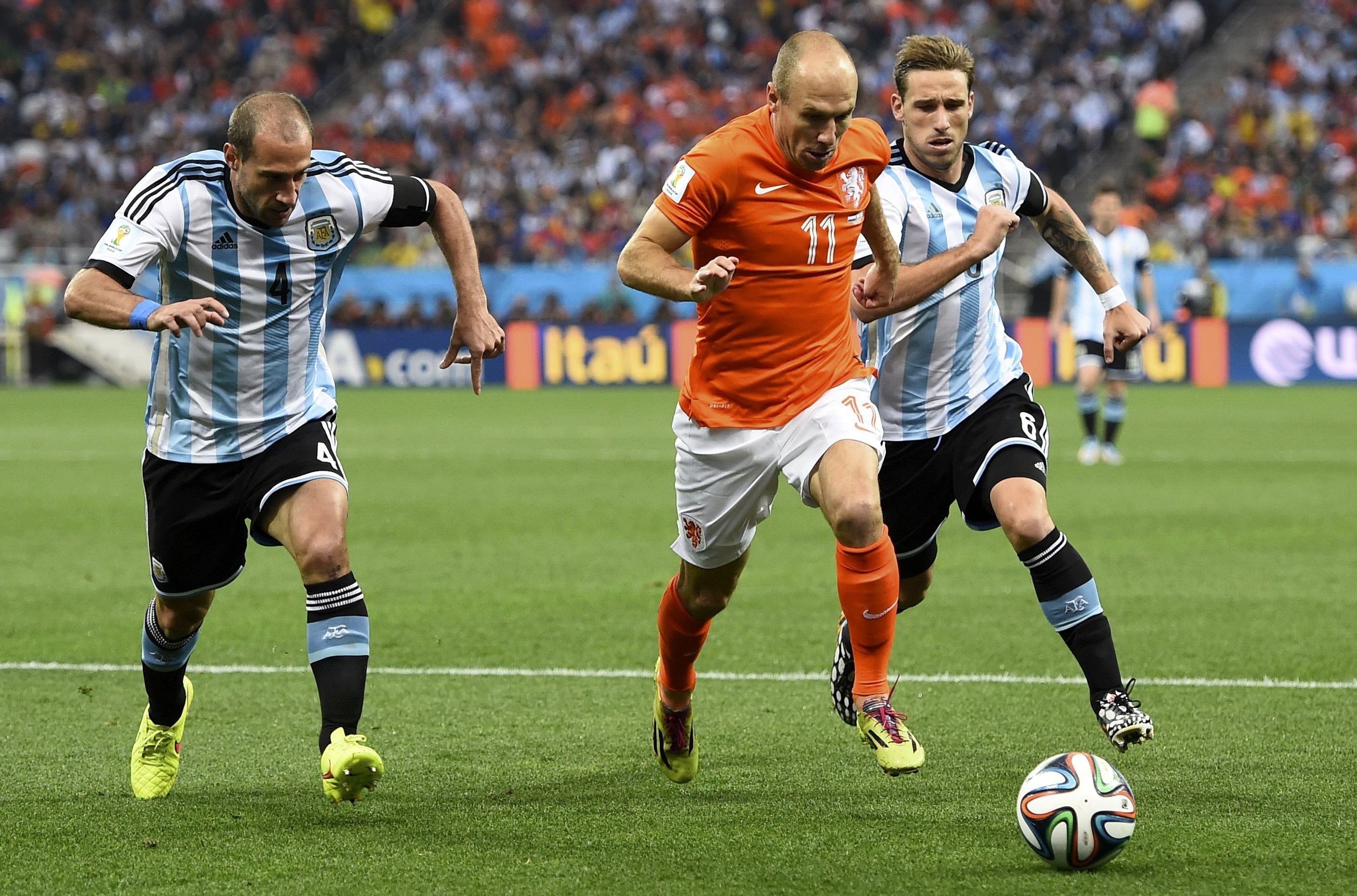 Robben (c) conduce un balón perseguido por jugadores argentinos.