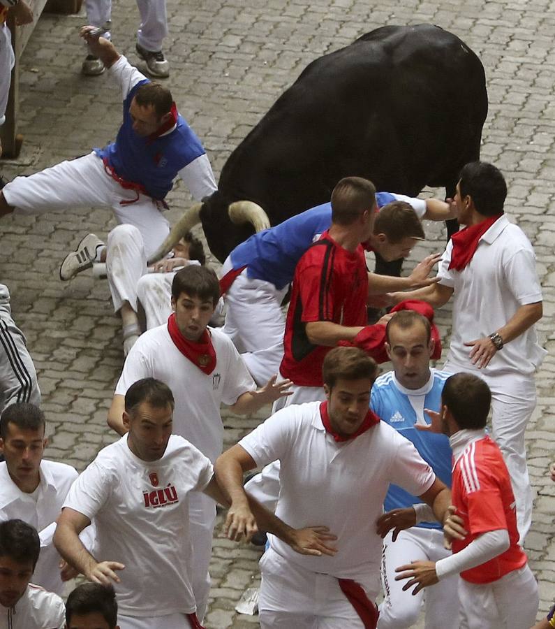 Peligroso encierro. Uno de los momentos más peligrosos del encierro, con un toro rezagado.