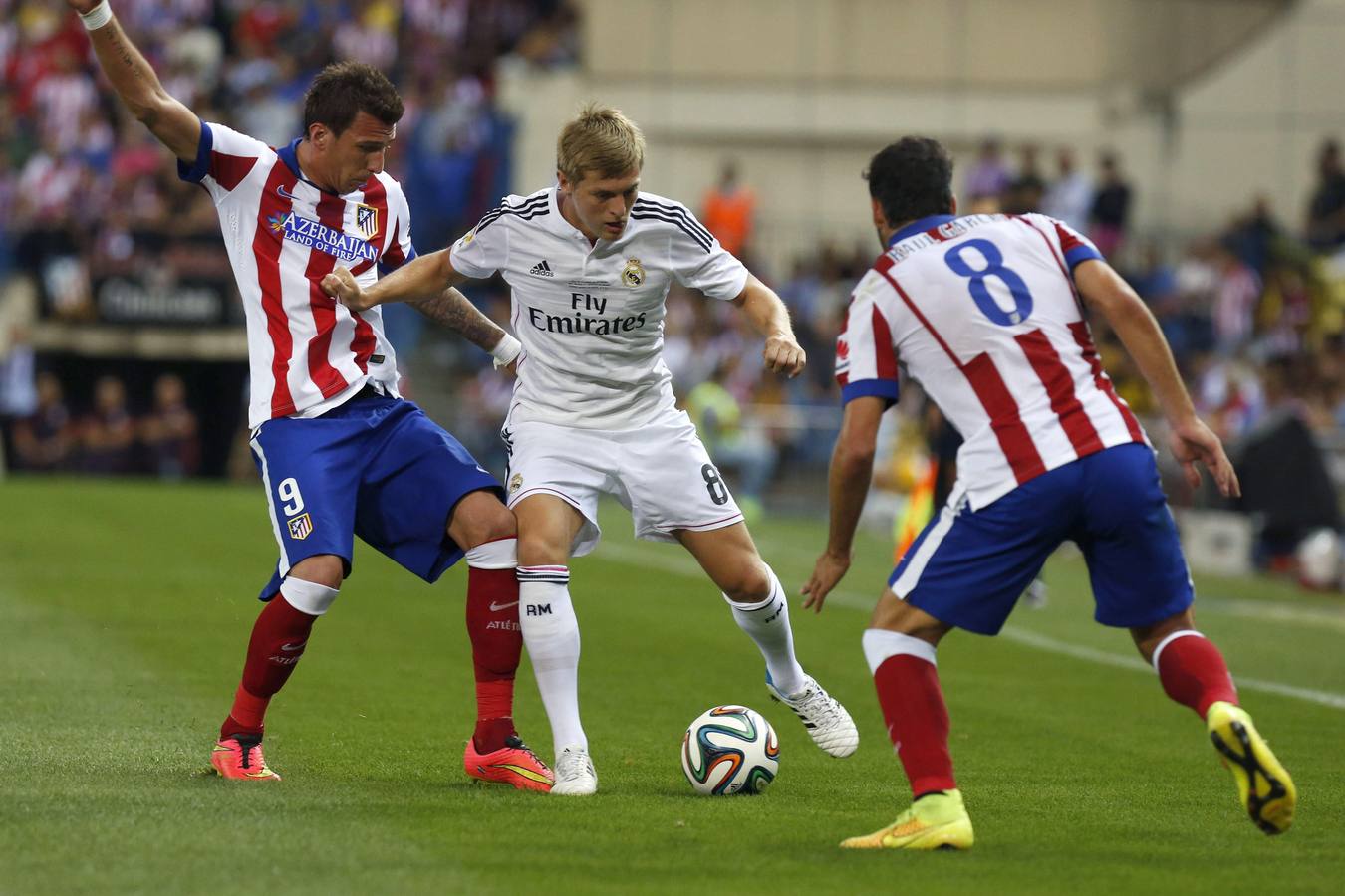 Kroos lucha un balón con Mandzukic y Raúl García.