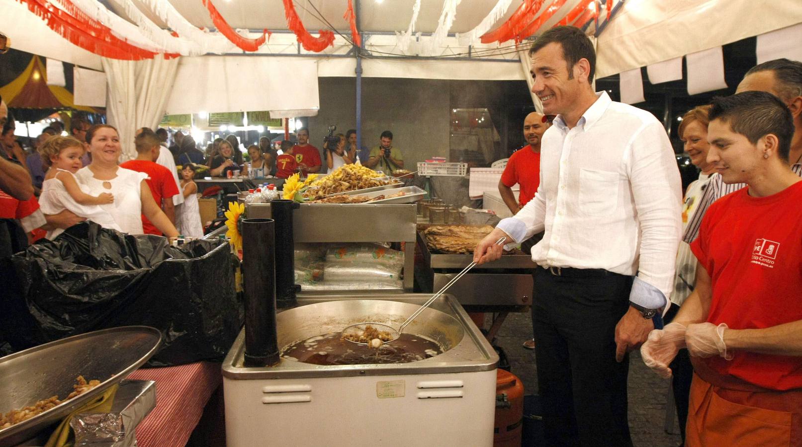 Tomás Gómez, en las fiestas de Madrid en un puesto de comida típica de la Comunidad.