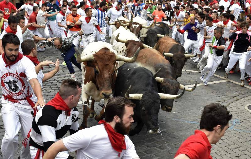 Mosos corriendo ante la aparición de los toros.