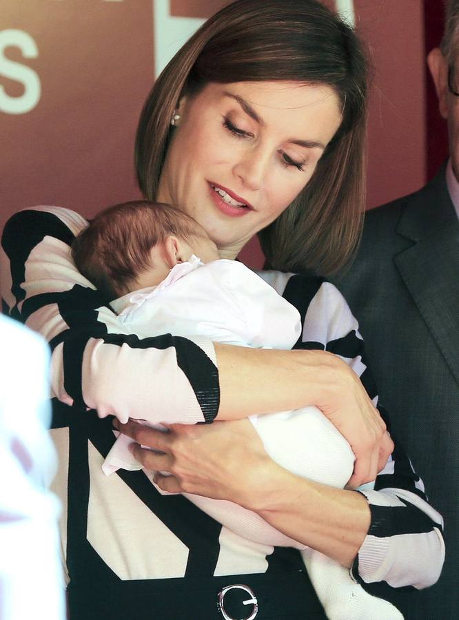 La reina Letizia sostiene a un bebé en la mesa de cuestación de Cruz Roja.