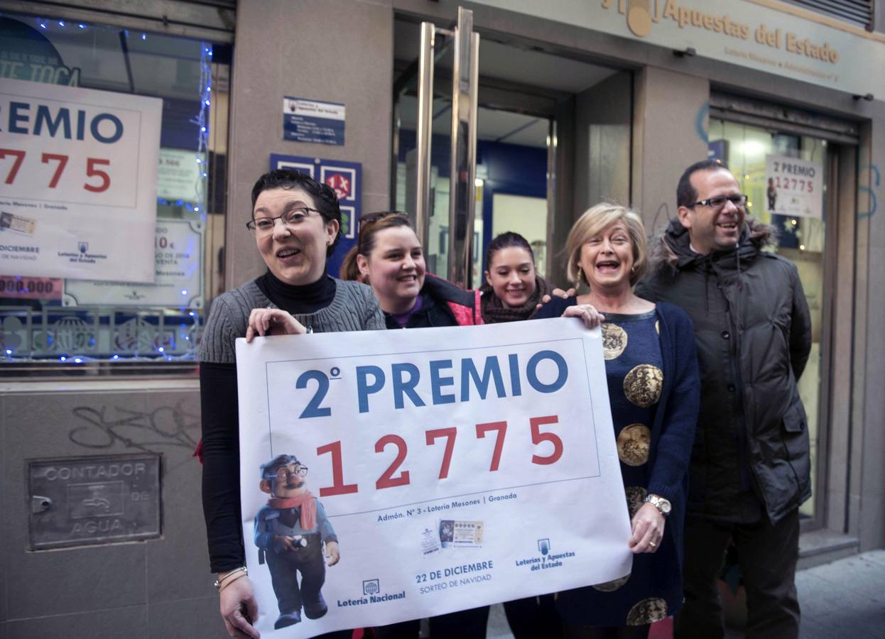 La propietaria de la administración de lotería nº3 de la calle Cerrajeros de Granada, Teresa Calvo (2d), junto a un grupo de vecinos y amigos celebran el segundo premio.