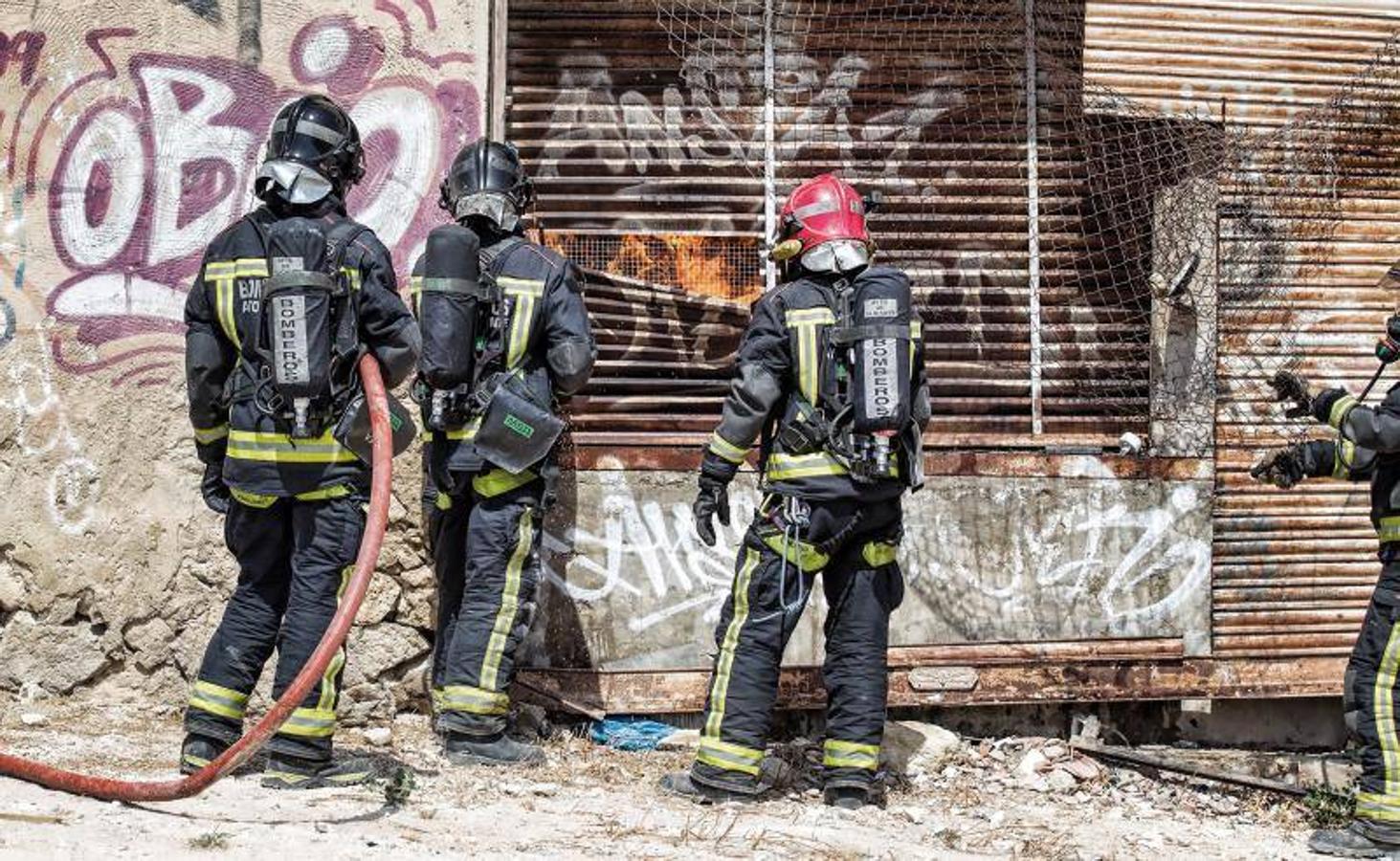 Los bomberos trabajan para extinguir un incendio en una nave abandonada