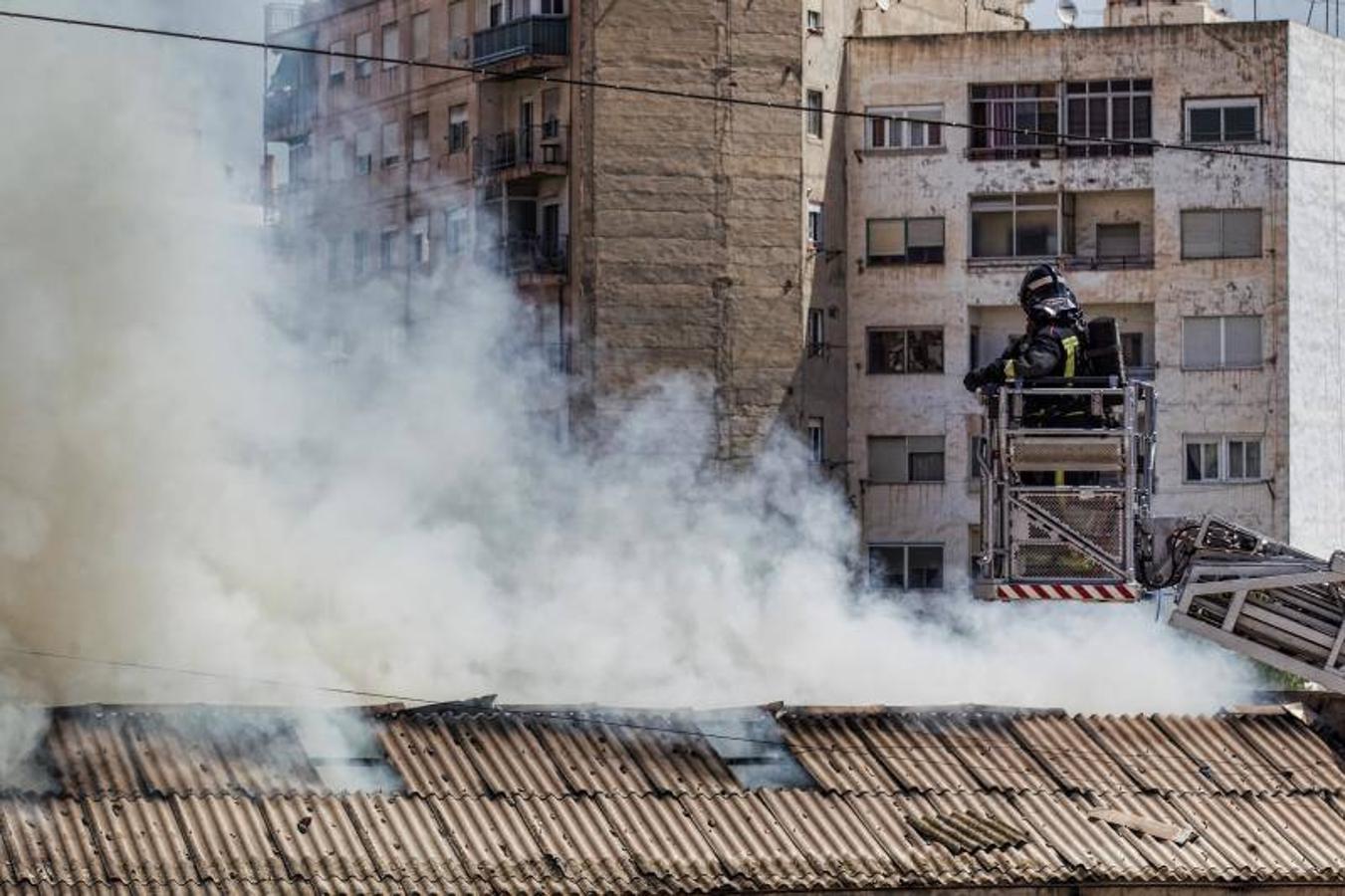 Los bomberos trabajan para extinguir un incendio en una nave abandonada