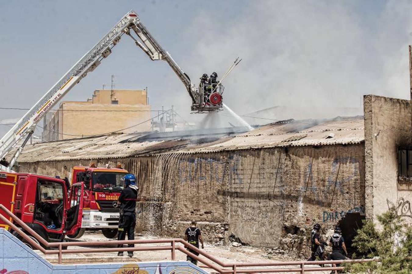 Los bomberos trabajan para extinguir un incendio en una nave abandonada