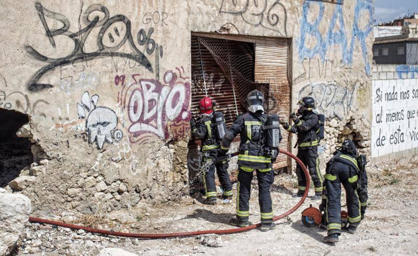 Los bomberos trabajan para extinguir un incendio en una nave abandonada