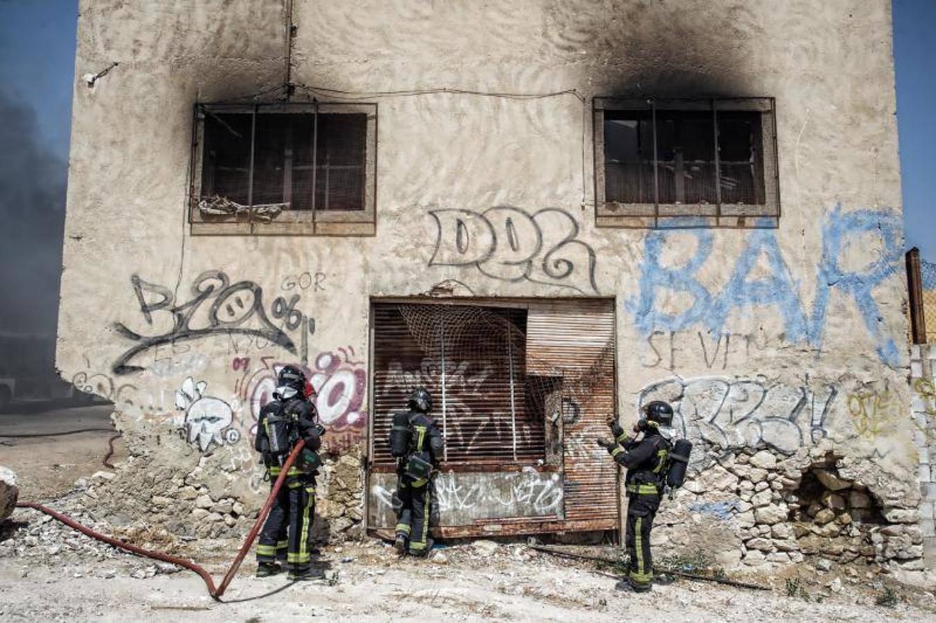 Los bomberos trabajan para extinguir un incendio en una nave abandonada