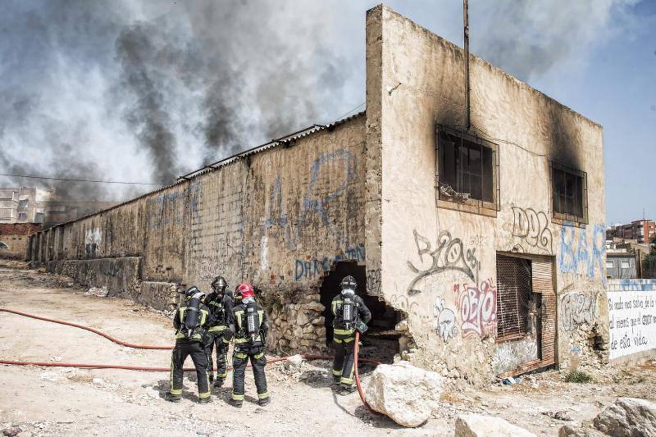 Los bomberos trabajan para extinguir un incendio en una nave abandonada