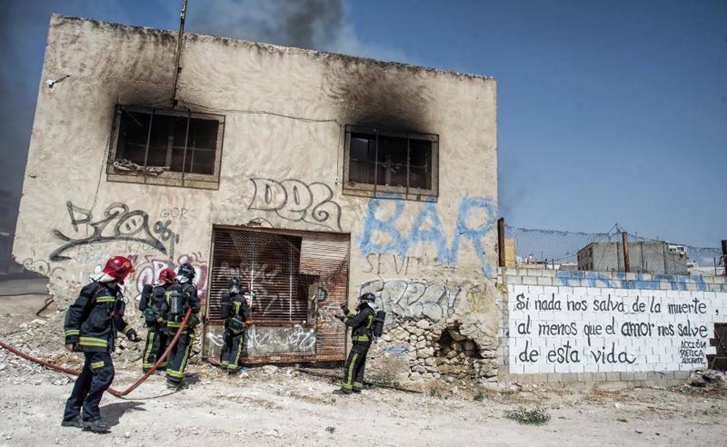 Los bomberos trabajan para extinguir un incendio en una nave abandonada